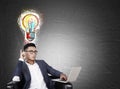 Asian man with laptop and colorful light bulb Royalty Free Stock Photo