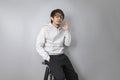 Asian man listen to the music via earpod sitting on chair