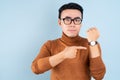 Asian man looking his watch on blue background Royalty Free Stock Photo