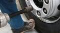 Mechanic changing truck wheel in auto repair shop by using workshop equipment tool.