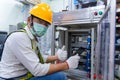 Asian man Mechanic wearing protective mask to Protect Against Covid-19,male technician worker working and checking the electric