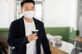 Asian man in medical with coffee going in store