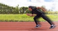 Asian man motion acting or show running on racetrack at outdoor sports field in bright day Royalty Free Stock Photo