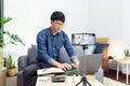 Asian man online influencer recording video live streaming, using digital smartphone camera present product review for theme about Royalty Free Stock Photo