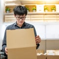 Asian man opening cardboard box lid Royalty Free Stock Photo