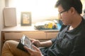 Asian man palying game on tablet at home Royalty Free Stock Photo