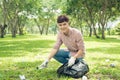 Asian man picking up plastic household waste in park Royalty Free Stock Photo