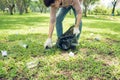 Asian man picking up plastic household waste in park. Royalty Free Stock Photo