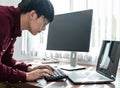 Asian man programmer looking on screen laptop to typing code data with keyboard about website and applications
