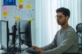 Asian man prompt engineer develop coding app with software data sitting in front of computer monitor at office Royalty Free Stock Photo