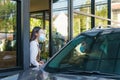 Asian man in protective mask order food and coffee with woman waitress wearing face mask and face shield at drive thru during Royalty Free Stock Photo