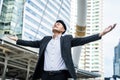 Asian man raise hand with happiness in city feels glad to get new job. Young businessman feeling happy and free after he knew the Royalty Free Stock Photo