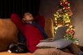 An Asian man resting on a couch with his cat, taking nap, spending Christmas night at home Royalty Free Stock Photo