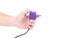 The Asian man's hand is holding a purple power plug or electric adapter isolated on white background Royalty Free Stock Photo