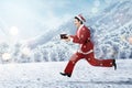 Asian man in Santa costume running while holding the gift box Royalty Free Stock Photo