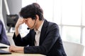 Asian man Serious call center operator in wireless headset talking with customer,in customer support service Royalty Free Stock Photo