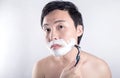 Asian man is shaving