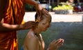 Asian man shaving his head by elder monk before ordain ceremony