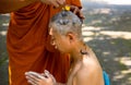 Asian man shaving his head by elder monk before ordain ceremony