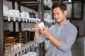 Asian man shop owner holding ceramic cup from shelf