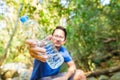 A man show bottled drinking water in the forest