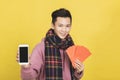 Asian man showing red envelpoe and mobile phone screen,  celebrating chinese new year concept Royalty Free Stock Photo