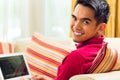 Asian man sitting on couch surfing the internet Royalty Free Stock Photo