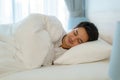 Asian man are sleeping and having good dreams in white blanket in the morning. Rest after work tiring in bedroom at home Royalty Free Stock Photo