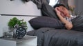 Man sleeping in his bedroom alarm clock in foreground. Royalty Free Stock Photo