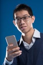 Asian man with smartphone accessing apps, internet, and AI