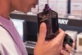 Asian man smells Mr. Burberry perfume in a fragrance shop