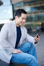 Asian man smiling with cellphone Royalty Free Stock Photo