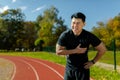 Asian man in sports training has severe heart pain, athlete with heart attack attack in stadium holding hand to chest Royalty Free Stock Photo