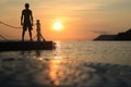 Asian man standing on floating pier at sunrise , Silhouette body of asian people early morning on the beach by the sea Royalty Free Stock Photo