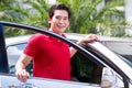 Asian man standing in front of car