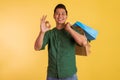 asian man standing with oke hand gesture and holding the shopping bags Royalty Free Stock Photo