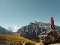 Asian man standing on top of rock looking at Mount Yangmaiyong or Jampayang in Tibetan in Yading, China Royalty Free Stock Photo