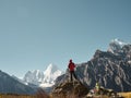 Asian man standing on top of rock looking at Mount Yangmaiyong or Jampayang in Tibetan in Yading, China Royalty Free Stock Photo