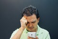 Asian man strain using smartphone in dark style Royalty Free Stock Photo