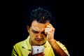Asian man strain using smartphone in dark style Royalty Free Stock Photo