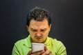 Asian man strain using smartphone in dark style Royalty Free Stock Photo