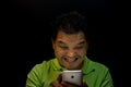 Asian man strain using smartphone in dark style Royalty Free Stock Photo