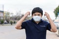 Asian man in the street wearing protective masks., Sick man with flu wearing mask and blowing nose into napkin as epidemic flu con Royalty Free Stock Photo