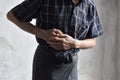 Asian man suffering from abdominal pain. It can be caused by stomach ache, enteritis, colitis, appendicitis, hepatitis, food