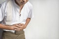 Asian man suffering from upper abdominal pain. It can be caused by stomach ache, enteritis, colitis, appendicitis, hepatitis,