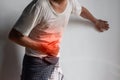 Asian man suffering from upper abdominal pain. It can be caused by stomach ache, enteritis, colitis, appendicitis, hepatitis,