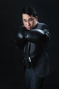 Asian man in suit wearing boxing gloves