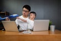 Asian man it support working on computer laptop to remote desktop with his son.