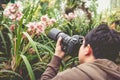 Asian man taking photo beautiful orchid flowers in a orchid hou