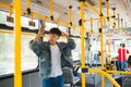 Asian man taking public transport, standing inside bus. Royalty Free Stock Photo